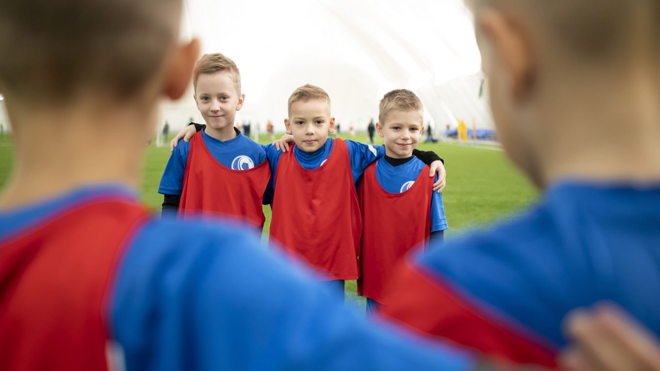 Crianças jogando futebol com roupas esportivas